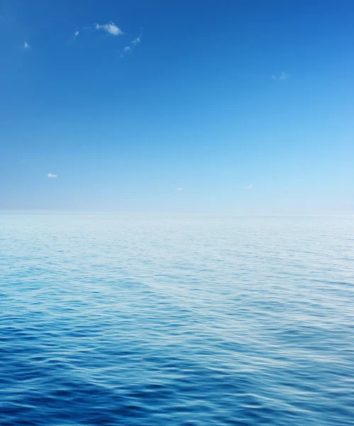 Море с голубым небом и редкими облаками — стоковое фото