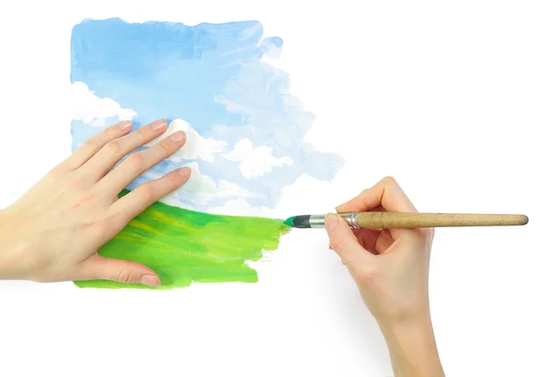 Hands with brush and bright nature image — Stock Photo, Image