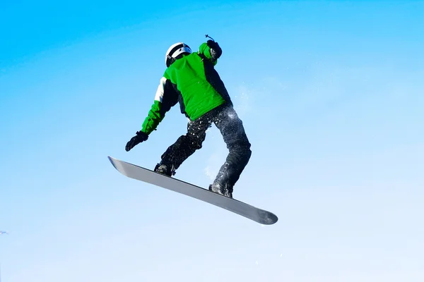 Snowboarder no salto sobre o céu azul claro — Fotografia de Stock
