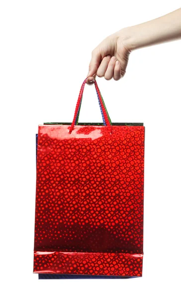 Mano che tiene una borsa rossa sopra bianco — Foto Stock