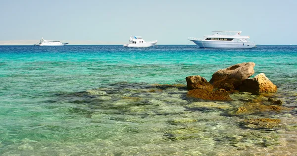 A tengerre és a partján sziklák fehér jachtok — Stock Fotó