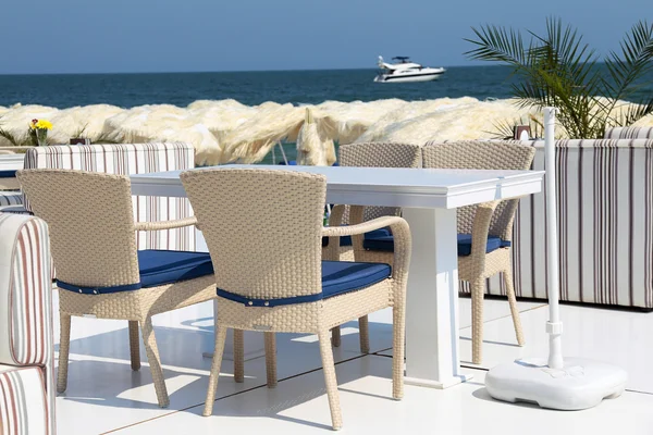 stock image Dining table and chairs on the beach on a summer day