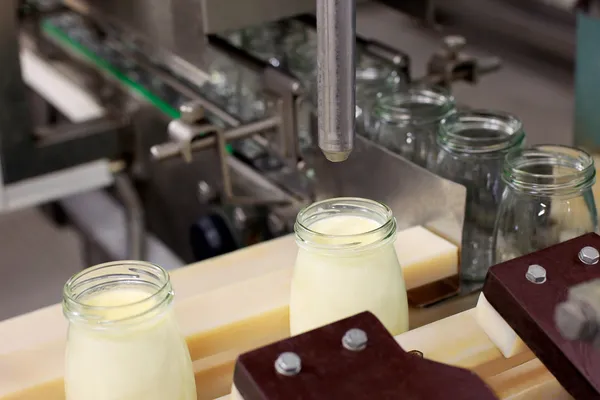 Конвейер с бутылками с молочными продуктами — стоковое фото