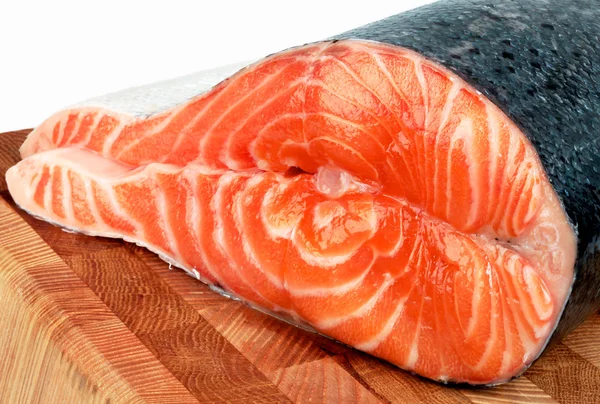 Un trozo de salmón en la sección de pescado en una tabla de cortar —  Fotos de Stock