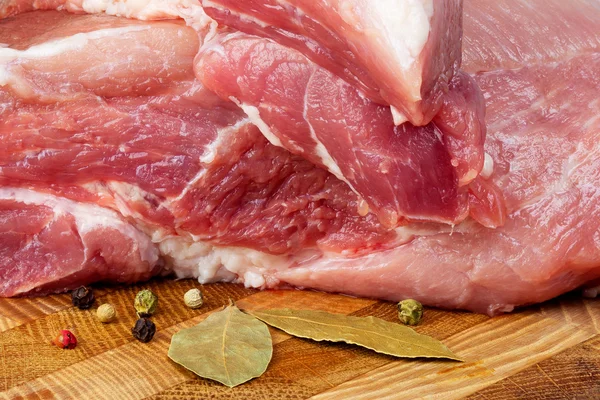 Een stuk varkensvlees op een snijplank — Stockfoto