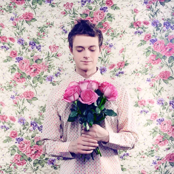 Ung, vakker mann med blomster. – stockfoto
