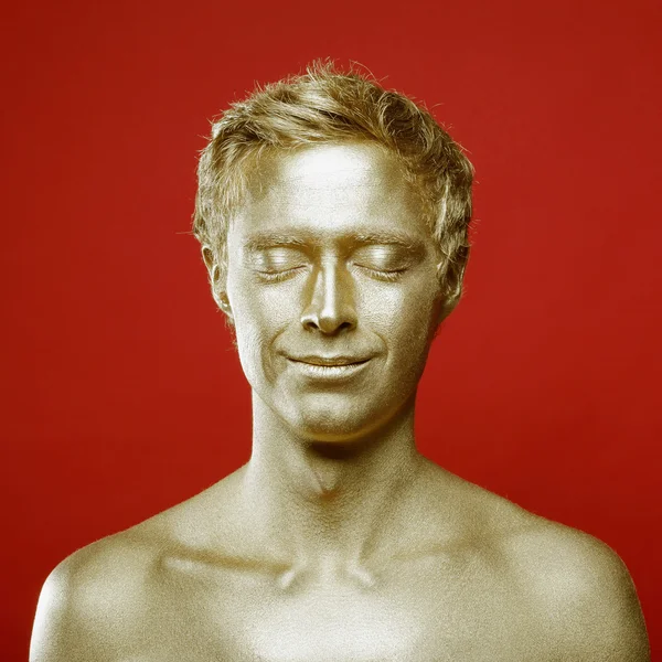 Porträt eines schönen Mannes mit goldenem Körper — Stockfoto