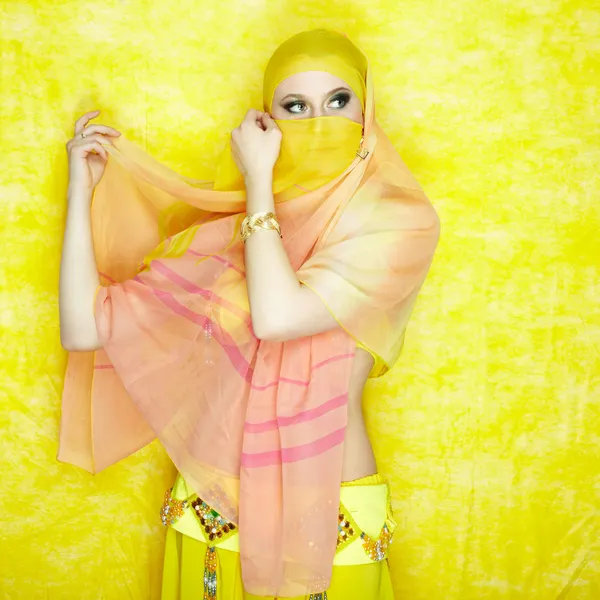 Jovem bela mulher está posando em paranja no fundo amarelo — Fotografia de Stock