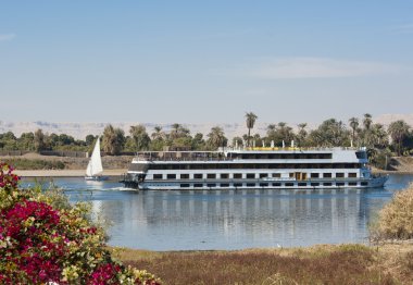 Nile river boat cruising through Luxor clipart