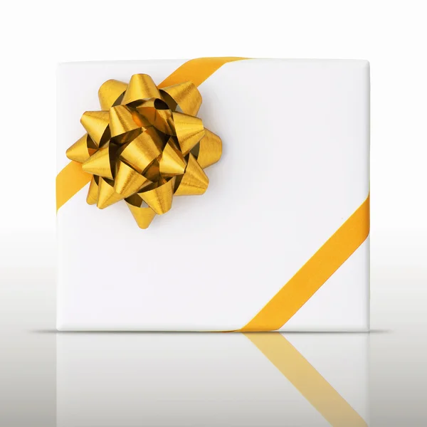 Estrela de ouro e fita de linha oblíqua na caixa de papel branco — Fotografia de Stock