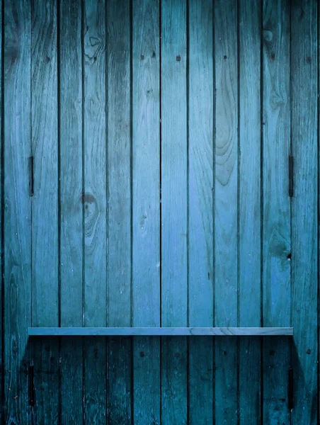 Madeira prateleira azul na parede com luz — Fotografia de Stock