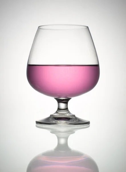 Rosa vin i brandy glas och reflektion — Stockfoto