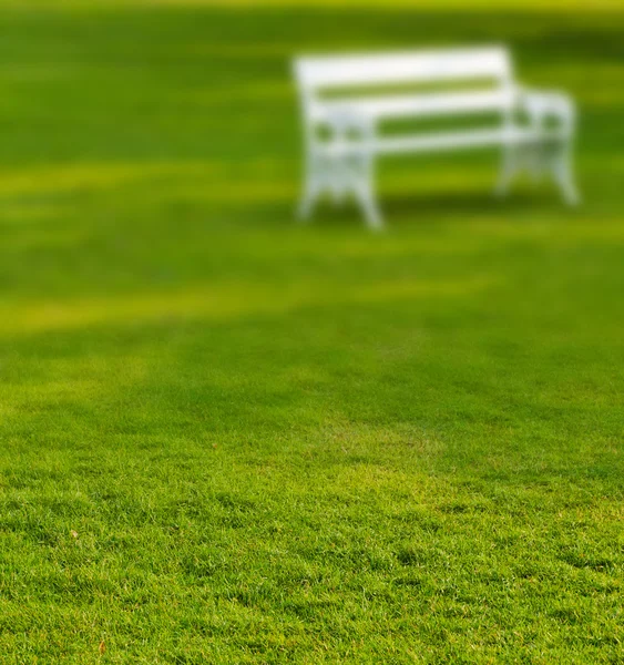 Bancada branca longa borrada no parque — Fotografia de Stock