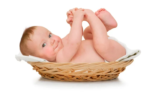 Hermoso bebé niño se encuentra en almohadilla y juega con sus propios pies — Foto de Stock