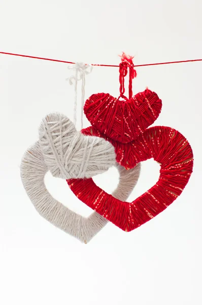 Hearts maden of red and grey threads is hangings on a rope — Stock Photo, Image