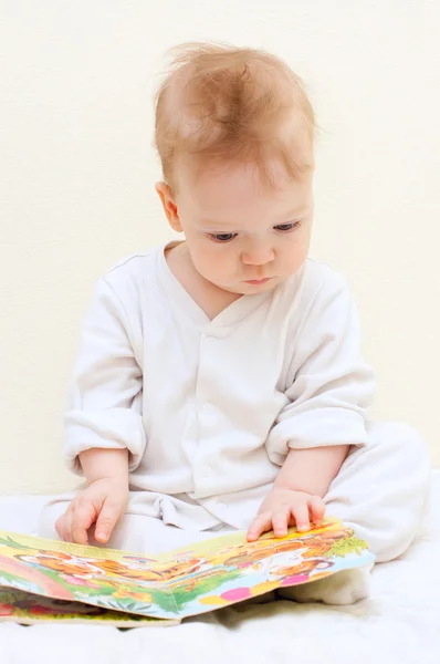 Un niño de un año lee libro para niños — Foto de Stock