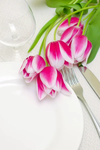 I tulipani rosa teneri abbelliscono una tavola apparecchiata. Esempio copia spazio pro — Foto Stock