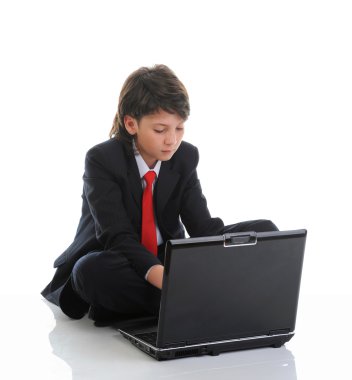bilgisayar başında oturan takım elbise içindeki çocuk