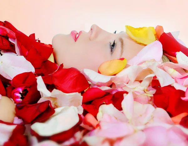Piękna blondynka w płatkach róży — Zdjęcie stockowe