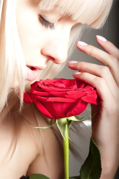 Frau, die eine Rose riecht — Stockfoto