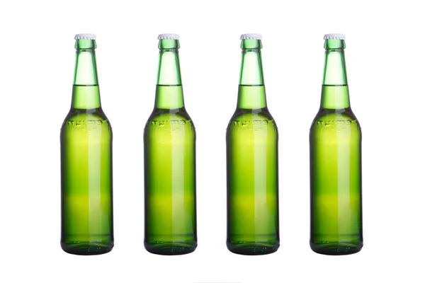 Beyaz zemin üzerine dört yeşil bira şişeleri — Stok fotoğraf