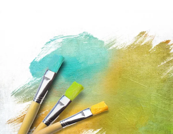 Artist brushes with a half finished painted canvas — Stock Photo, Image