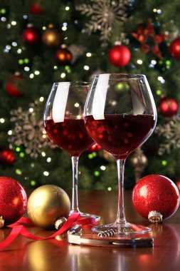 Glasses of red wine in front of Christmas tree clipart