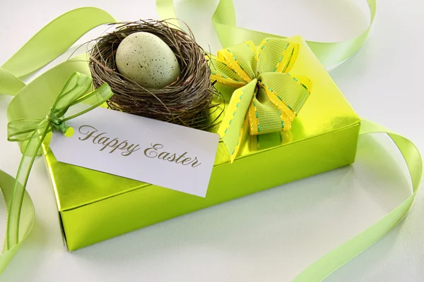 Regalo, tarjeta y huevo en el nido para Pascua — Foto de Stock