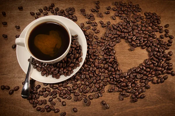 Kształt serca z ziaren kawy na drewno — Zdjęcie stockowe