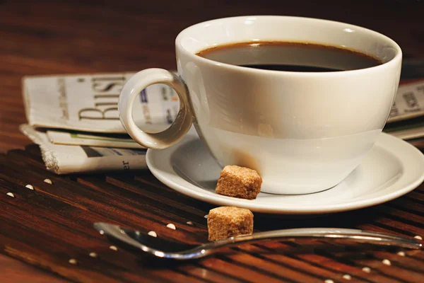 Xícara de café e jornal. Concentre-se no punho do copo — Fotografia de Stock