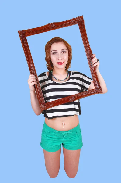 Kneeling girl with picture frame. — Stock Photo, Image