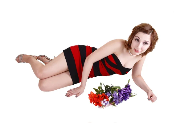 Girl lying on floor with flowers. — Stock Photo, Image