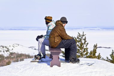 dağın tepesinde oturan iki snowboard düşkünleri