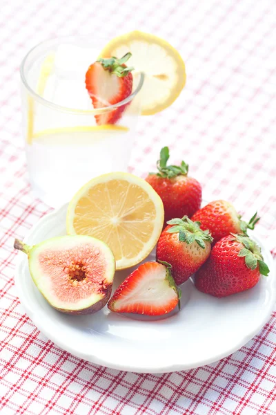 Cóctel con hielo, limón, higo y fresas en un plato —  Fotos de Stock
