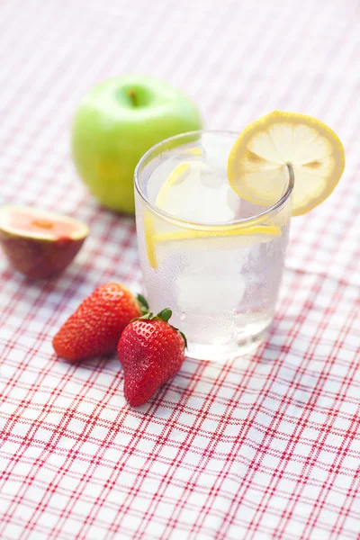 Cóctel con hielo, limón, manzana, higo y fresas en un plato — Foto de Stock