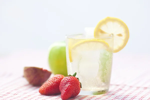 Cocktail with ice,lemon,apple, fig and strawberries on a plate — Stock Photo, Image