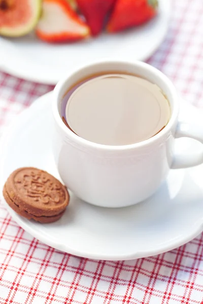 Šálek čaje, souboru cookie, fík a jahody na talíři — Stock fotografie