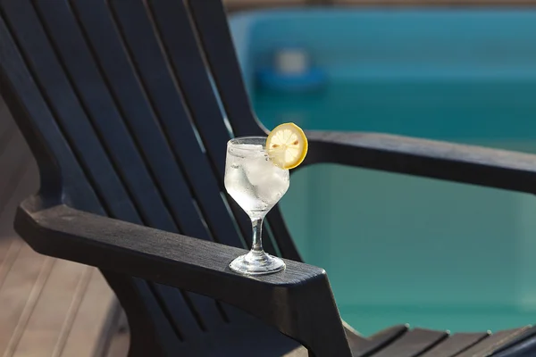 Piscina, salão, um copo de vinho com gelo, limão e palha — Fotografia de Stock