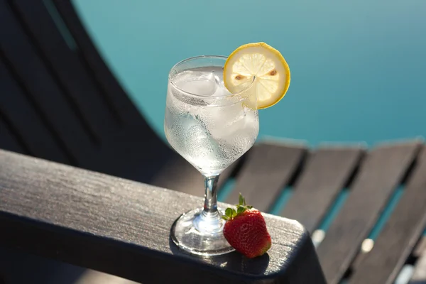 Piscina, salón, una copa de vino con hielo, limón y fresa — Foto de Stock