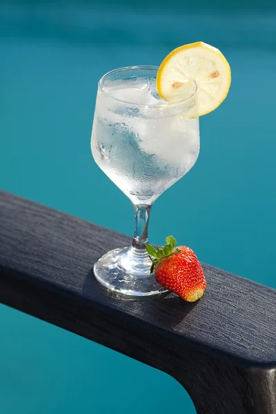 Piscina, salón, una copa de vino con hielo, limón y fresa — Foto de Stock