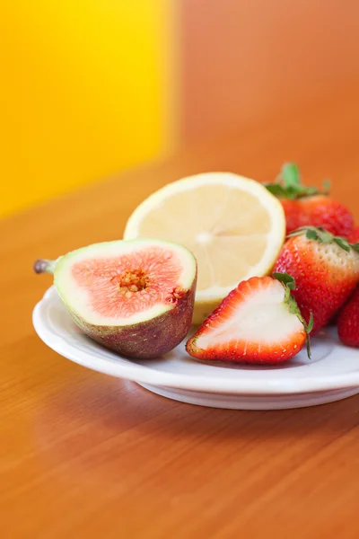 Limón, higo y fresas en un plato — Foto de Stock