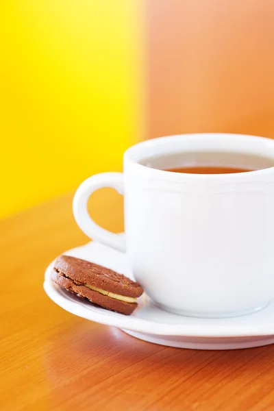 Filiżankę herbaty i ciasteczka na stole — Zdjęcie stockowe