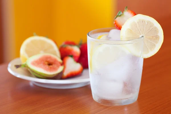 Cocktail met ijs, citroen, vijgen en aardbeien op een plaat — Stockfoto