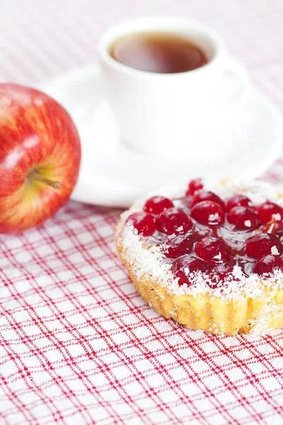 Vacker tårta med bär, äpple och te på rutigt tyg — Stockfoto