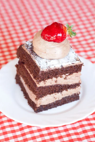 Beautiful cake with strawberry on plaid fabric — Stock Photo, Image