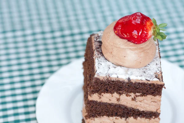 Vacker tårta med jordgubbe på rutigt tyg — Stockfoto
