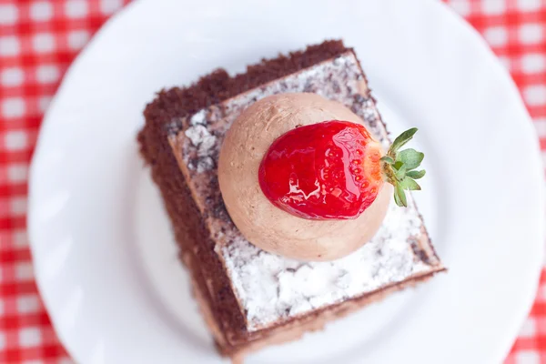 Schöne Torte mit Erdbeere auf kariertem Stoff — Stockfoto