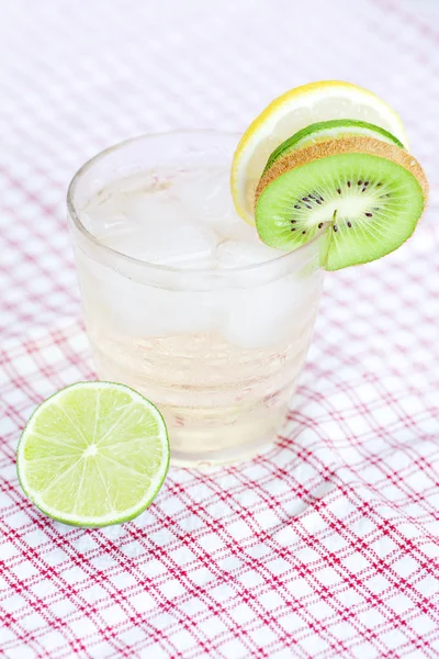 Water met citroen en limoen, kiwi in een glas met ijs — Stockfoto