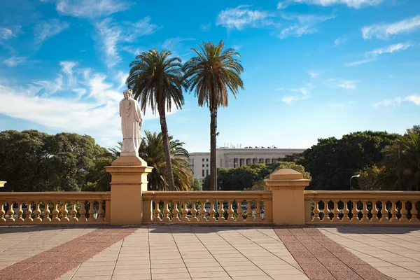 Balcony with a statue on a background of palm trees and blue sky — Stock Photo, Image