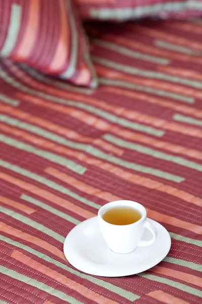 Säng med två kuddar, en kopp te på filten — Stockfoto